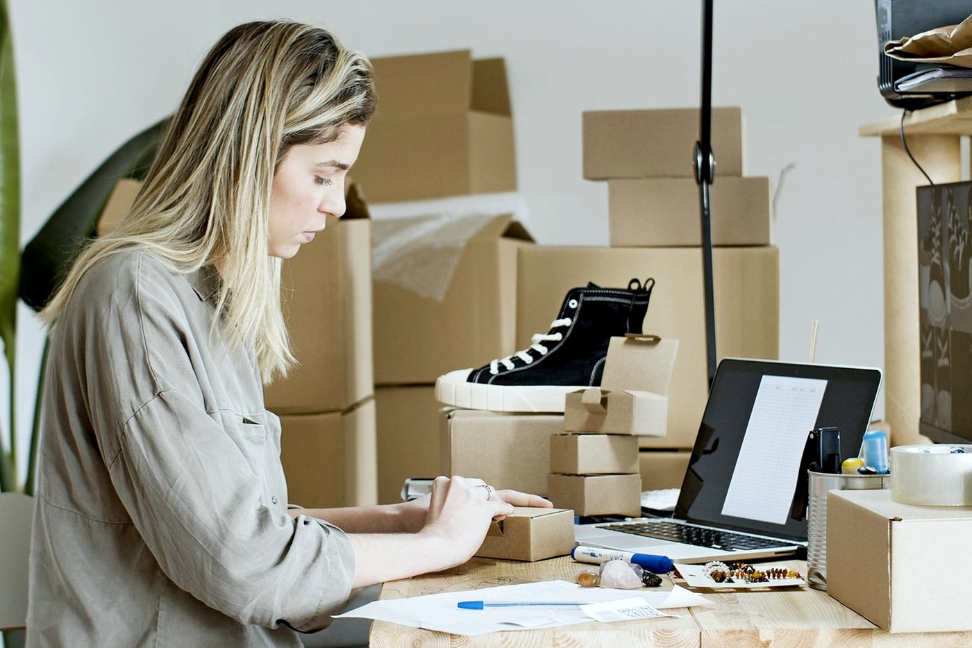 Packing finished handmade items into boxes at a home work table
